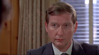 Movie still from “A New Leaf” (1971), directed by Elaine May – A person wearing a suit and tie; Close Up shot, Over the shoulder angle