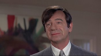 Movie still from “A New Leaf” (1971), directed by Elaine May – A person wearing a suit and tie; Close Up shot, Over the shoulder angle