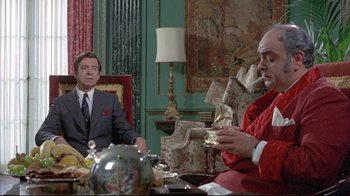 Movie still from “A New Leaf” (1971), directed by Elaine May – Two men sitting at a table in a room; Medium shot, Over the shoulder angle
