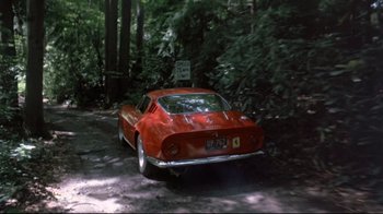 Movie still from “A New Leaf” (1971), directed by Elaine May – A red car is driving down a dirt road in the woods; Wide shot, High angle
