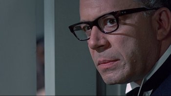 Movie still from “A New Leaf” (1971), directed by Elaine May – A person wearing a suit and glasses; Close Up shot, Over the shoulder angle