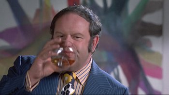Movie still from “A New Leaf” (1971), directed by Elaine May – A man in a suit and tie drinking a glass of beer; Close Up shot, Low angle
