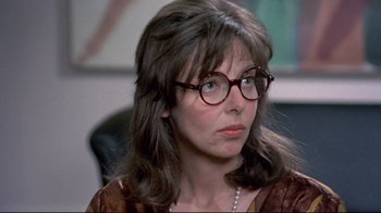 Movie still from “A New Leaf” (1971), directed by Elaine May – A person wearing glasses and a necklace; Close Up shot, Over the shoulder angle