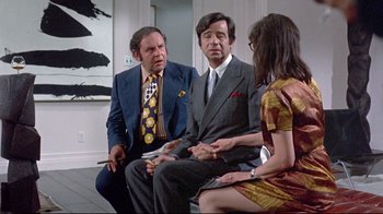 Movie still from “A New Leaf” (1971), directed by Elaine May – A group of men and a woman sitting in a room; Medium shot, Over the shoulder angle