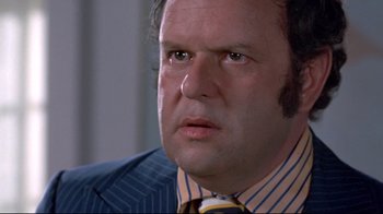 Movie still from “A New Leaf” (1971), directed by Elaine May – A person wearing a suit and tie; Close Up shot, Low angle