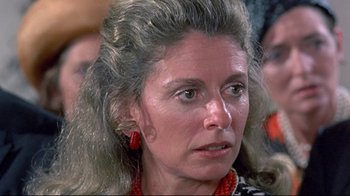 Movie still from “A New Leaf” (1971), directed by Elaine May – An older woman with long gray hair wearing red earrings; Close Up shot, Over the shoulder angle