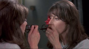 Movie still from “A New Leaf” (1971), directed by Elaine May – A woman holding a pair of glasses in front of a mirror; Close Up shot, Over the shoulder angle