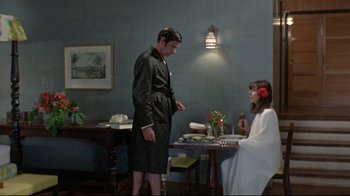 Movie still from “A New Leaf” (1971), directed by Elaine May – A man and a woman standing at a dinner table; Wide shot, High angle
