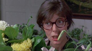 Movie still from “A New Leaf” (1971), directed by Elaine May – A woman holding a plant in front of her face; Close Up shot, Low angle