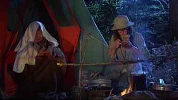 Movie still from “A New Leaf” (1971), directed by Elaine May – Two people sitting in front of a tent eating food; Medium shot, Low angle