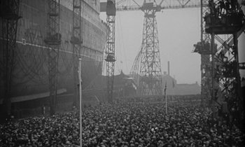 Movie still from “A Night to Remember” (1958), directed by Roy Ward Baker – A crowd of people standing in front of a large ship; Extreme Wide shot, High angle