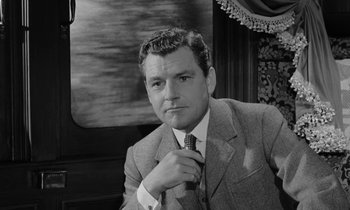 Movie still from “A Night to Remember” (1958), directed by Roy Ward Baker – Black and white photograph of a man adjusting his tie; Close Up shot, Low angle