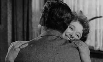 Movie still from “A Night to Remember” (1958), directed by Roy Ward Baker – A man and a woman embracing each other in front of a mirror; Close Up shot, Over the shoulder angle