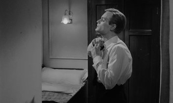 Movie still from “A Night to Remember” (1958), directed by Roy Ward Baker – A man in a white dress shirt and black tie fixing his bow tie; Close Up shot, Over the shoulder angle