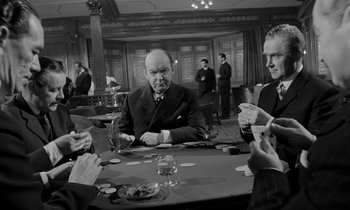 Movie still from “A Night to Remember” (1958), directed by Roy Ward Baker – A group of men sitting around a table playing cards; Medium shot, Over the shoulder angle