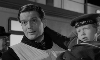 Movie still from “A Night to Remember” (1958), directed by Roy Ward Baker – A black - and - white photo of a man and a child; Medium shot, Low angle