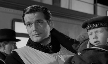 Movie still from “A Night to Remember” (1958), directed by Roy Ward Baker – A black - and - white photo of a man with a scarf; Close Up shot, Low angle