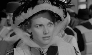 Movie still from “A Night to Remember” (1958), directed by Roy Ward Baker – A black and white photo of a woman wearing a hat; Close Up shot, Over the shoulder angle