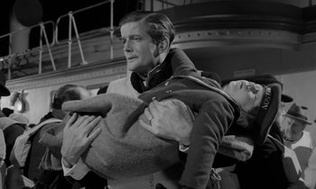 Movie still from “A Night to Remember” (1958), directed by Roy Ward Baker – A black and white photo of a man holding a child; Medium shot, High angle
