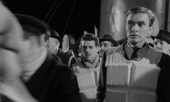 Movie still from “A Night to Remember” (1958), directed by Roy Ward Baker – A black and white photo of a group of men; Medium shot, Over the shoulder angle