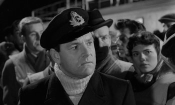 Movie still from “A Night to Remember” (1958), directed by Roy Ward Baker – A man wearing a hat and a jacket; Close Up shot, Low angle