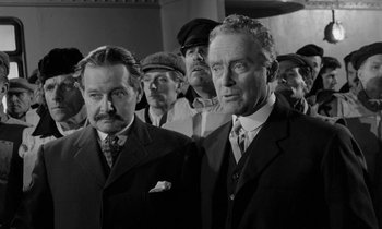 Movie still from “A Night to Remember” (1958), directed by Roy Ward Baker – A black and white photo of a group of men in suits; Medium shot, Low angle