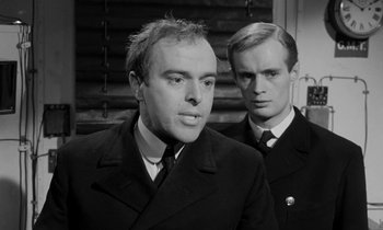 Movie still from “A Night to Remember” (1958), directed by Roy Ward Baker – A man in a suit and tie standing next to another man in a suit and tie; Close Up shot, Over the shoulder angle