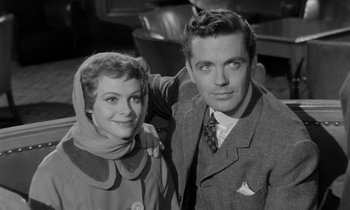 Movie still from “A Night to Remember” (1958), directed by Roy Ward Baker – A man and a woman posing for a picture; Medium shot, Low angle