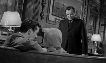 Movie still from “A Night to Remember” (1958), directed by Roy Ward Baker – A man standing next to a woman in front of two men; Medium shot, Over the shoulder angle