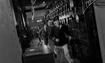 Movie still from “A Night to Remember” (1958), directed by Roy Ward Baker – A group of men walking through a room; Wide shot, Low angle