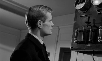 Movie still from “A Night to Remember” (1958), directed by Roy Ward Baker – A man in a suit looking into a mirror in a room; Close Up shot, Low angle