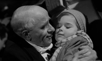 Movie still from “A Night to Remember” (1958), directed by Roy Ward Baker – An old man holding a little girl in his arms; Close Up shot, High angle