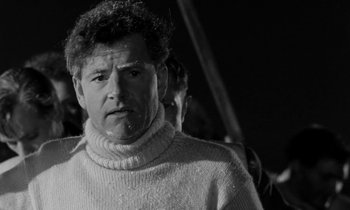 Movie still from “A Night to Remember” (1958), directed by Roy Ward Baker – A black and white photo of a man wearing a sweater; Close Up shot, Low angle