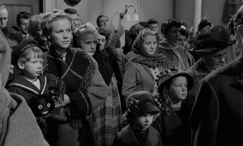 Movie still from “A Night to Remember” (1958), directed by Roy Ward Baker – A group of people standing in a room; Medium shot, High angle