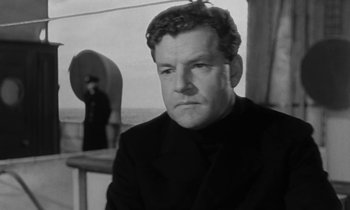 Movie still from “A Night to Remember” (1958), directed by Roy Ward Baker – A black and white photo of a man in a suit; Close Up shot, Low angle