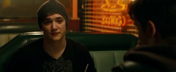 Movie still from “A Nightmare on Elm Street” (2010), directed by Samuel Bayer – A person sitting in a booth with a sign in the background; Close Up shot, Over the shoulder angle