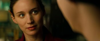 Movie still from “A Nightmare on Elm Street” (2010), directed by Samuel Bayer – A woman's face with a person taking a picture in the background; Close Up shot, Over the shoulder angle