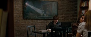 Movie still from “A Nightmare on Elm Street” (2010), directed by Samuel Bayer – A man sitting at a table in front of an open book; Wide shot, Low angle