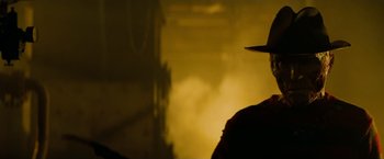 Movie still from “A Nightmare on Elm Street” (2010), directed by Samuel Bayer – A man wearing a hat standing in front of a building; Close Up shot, Low angle