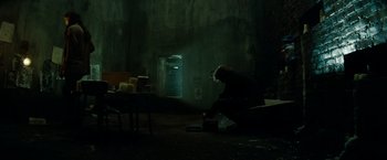 Movie still from “A Nightmare on Elm Street” (2010), directed by Samuel Bayer – A person sitting on the ground in a dark room; Wide shot, High angle
