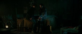 Movie still from “A Nightmare on Elm Street” (2010), directed by Samuel Bayer – Two people sitting on a bed in a dark room; Medium shot, High angle