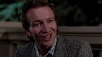 Movie still from “A Nightmare on Elm Street 3: Dream Warriors” (1987), directed by Chuck Russell – A person wearing a suit and smiling; Close Up shot, Over the shoulder angle