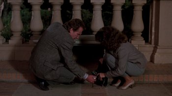 Movie still from “A Nightmare on Elm Street 3: Dream Warriors” (1987), directed by Chuck Russell – A man kneeling down next to a woman holding a camera; Medium shot, High angle
