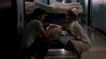 Movie still from “A Nightmare on Elm Street 3: Dream Warriors” (1987), directed by Chuck Russell – A man and a woman dressed as nurses in front of a stack of towels; Medium shot, Over the shoulder angle