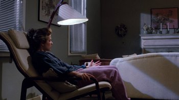 Movie still from “A Nightmare on Elm Street 3: Dream Warriors” (1987), directed by Chuck Russell – A man sitting in a chair under a lamp; Wide shot, Over the shoulder angle