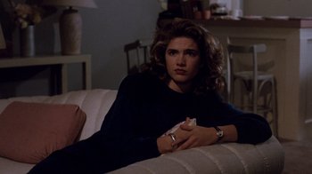 Movie still from “A Nightmare on Elm Street 3: Dream Warriors” (1987), directed by Chuck Russell – A woman sitting on a couch holding a nintendo wii game controller; Medium shot, High angle