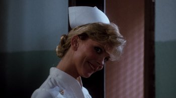 Movie still from “A Nightmare on Elm Street 3: Dream Warriors” (1987), directed by Chuck Russell – A woman wearing a nurse's uniform smiling for the camera; Close Up shot, Low angle