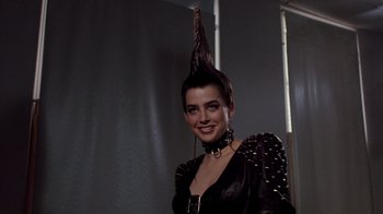 Movie still from “A Nightmare on Elm Street 3: Dream Warriors” (1987), directed by Chuck Russell – A woman in a black dress with a spiked mohawk on her head; Close Up shot, Low angle