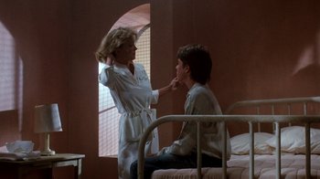 Movie still from “A Nightmare on Elm Street 3: Dream Warriors” (1987), directed by Chuck Russell – A woman is putting something on a young boy's face; Medium shot, Over the shoulder angle