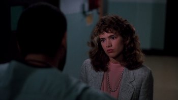 Movie still from “A Nightmare on Elm Street 3: Dream Warriors” (1987), directed by Chuck Russell – A woman in a suit is looking into a mirror; Close Up shot, Over the shoulder angle